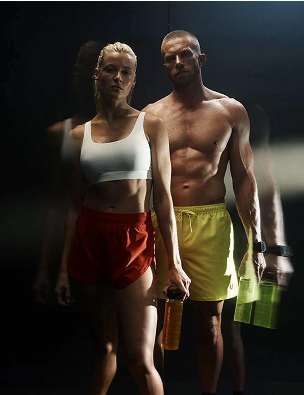 Two athletes carrying Instant Hydration bottles